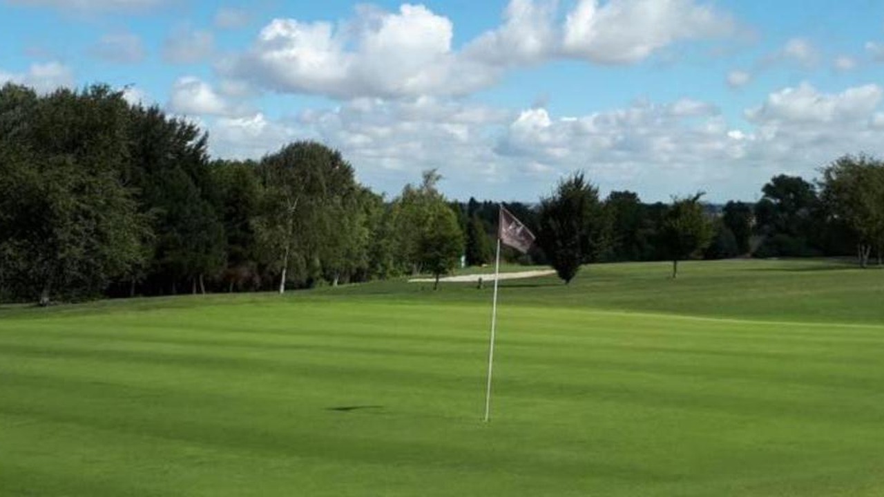 Green avec drapeau et fairway bordé d’arbres au Cap Golf Club du Bois de Ruminghem.