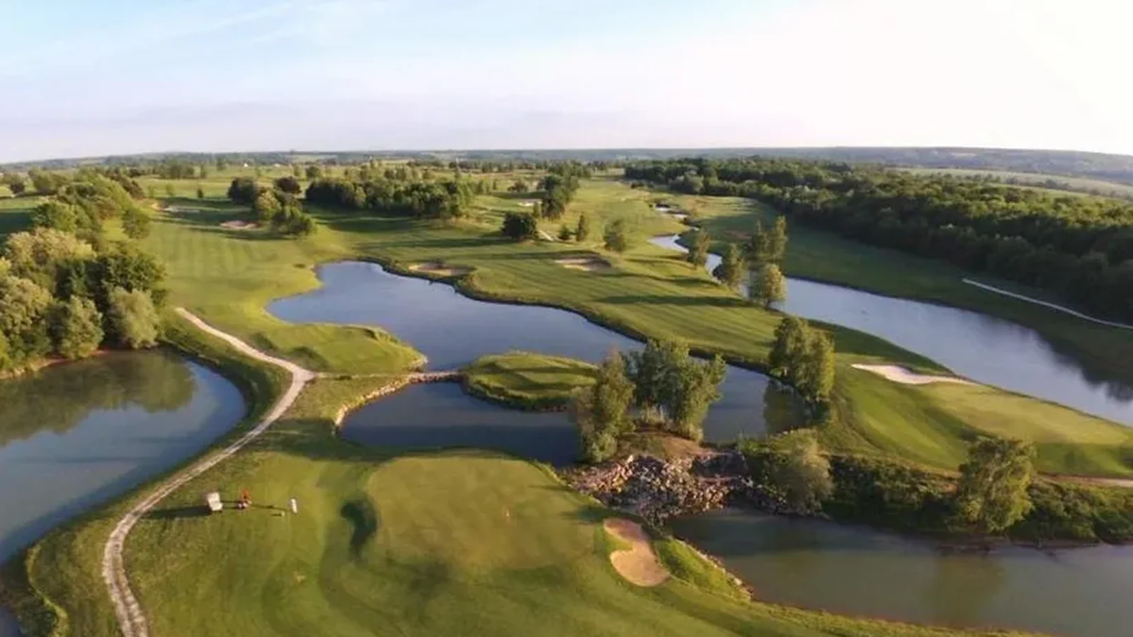 Vue aérienne des fairways, greens et plans d’eau de Crécy Golf.