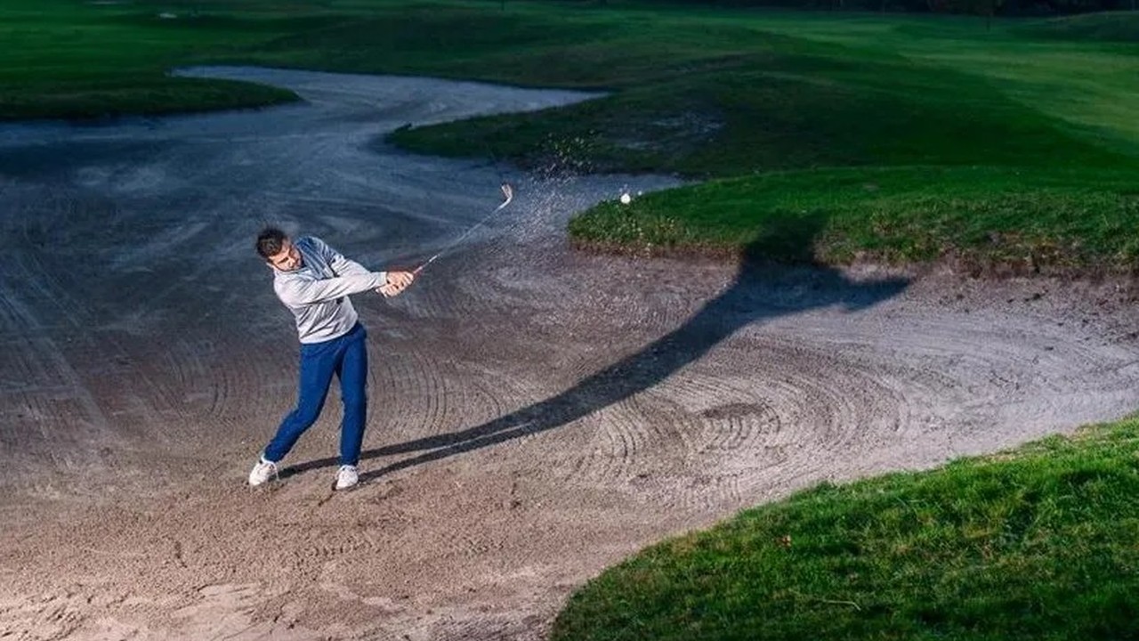 Golfeur effectuant une sortie de bunker au Golf Bluegreen Pessac.