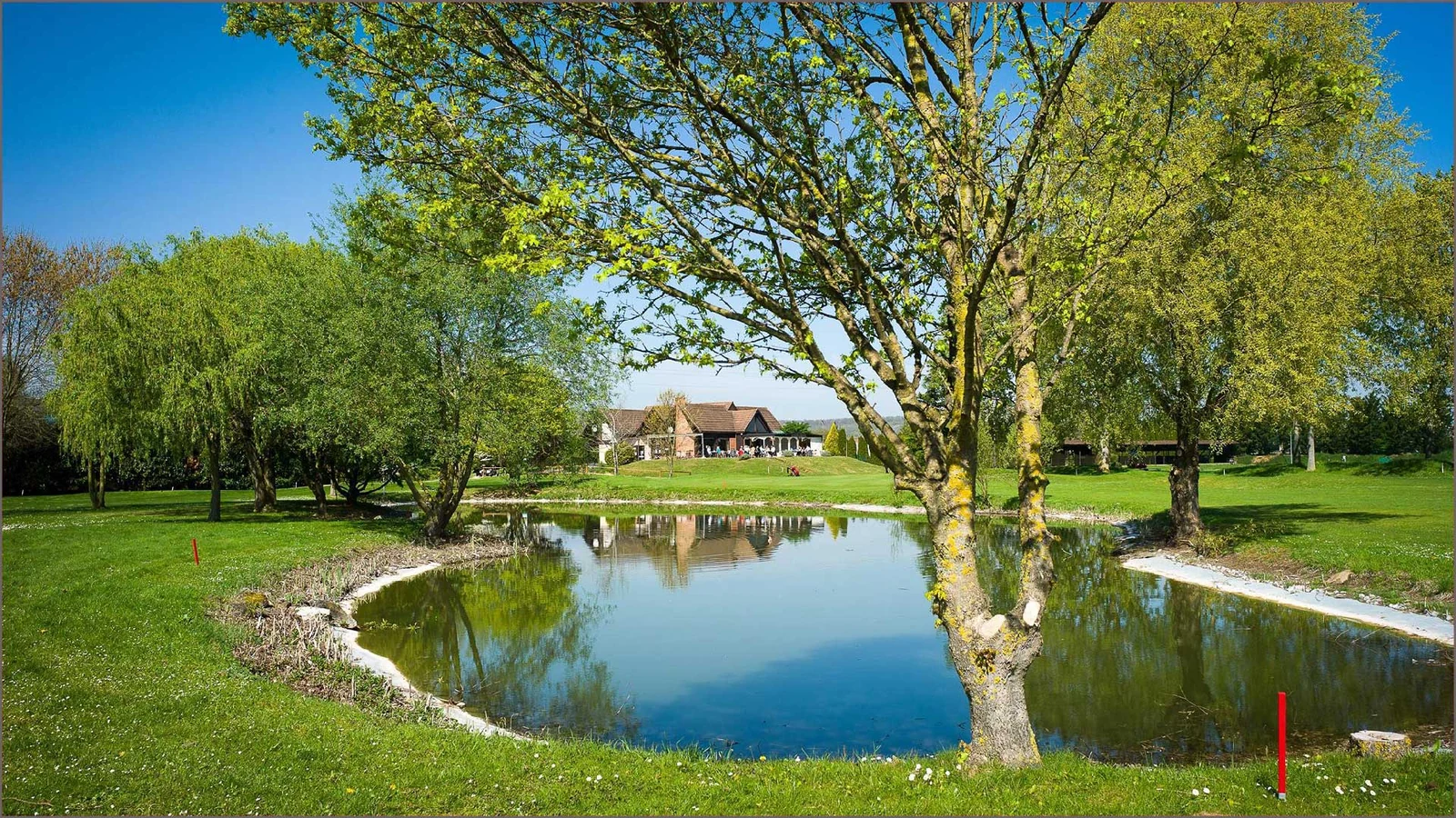 Green bordé d’un plan d’eau au Golf de Gaillon.
