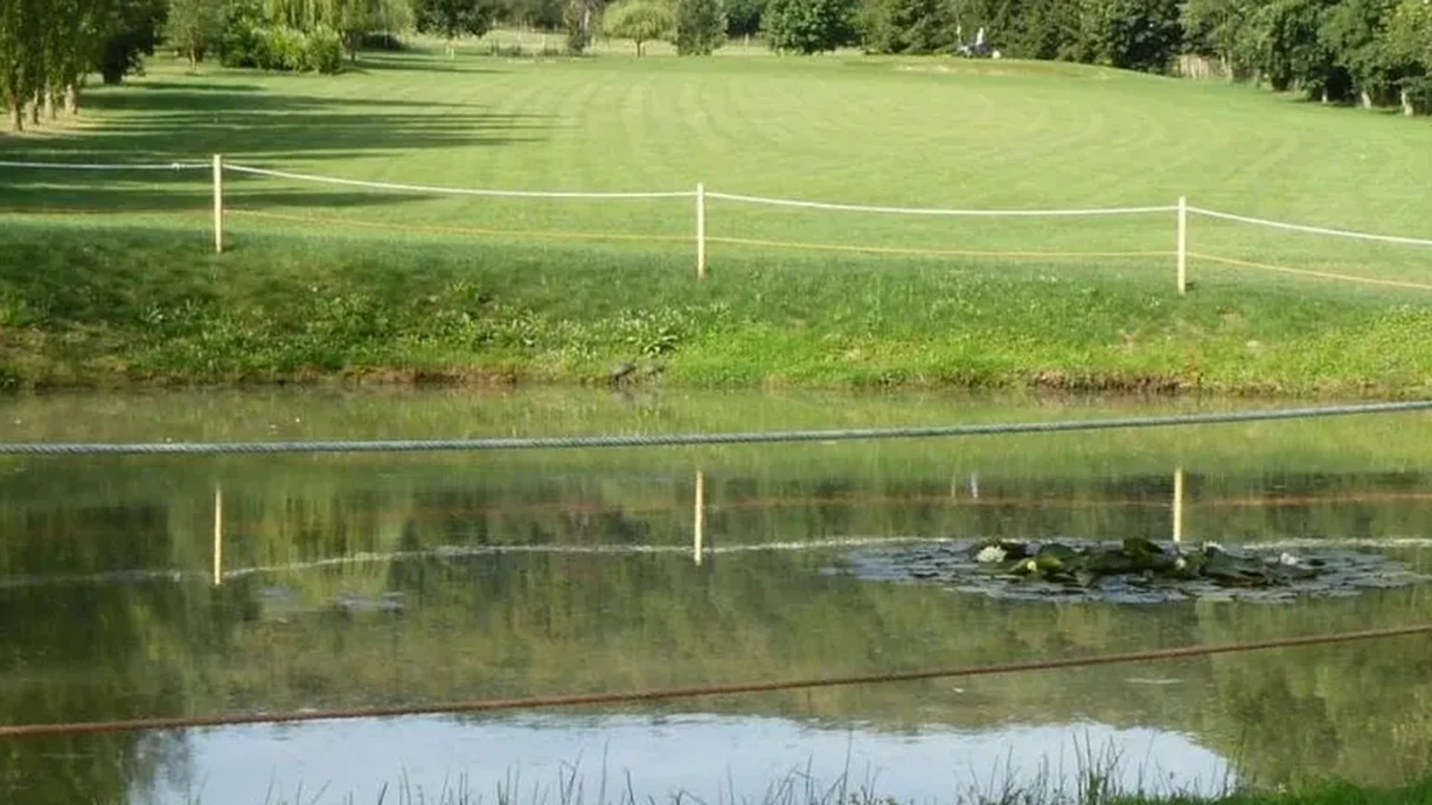 Fairway du Golf d’Écancourt derrière un plan d’eau.