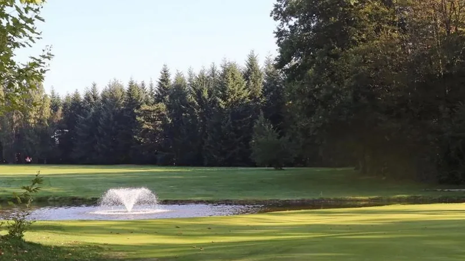 Green arboré et obstacle d’eau avec fontaine au Golf d’Ozoir-la-Ferrière.