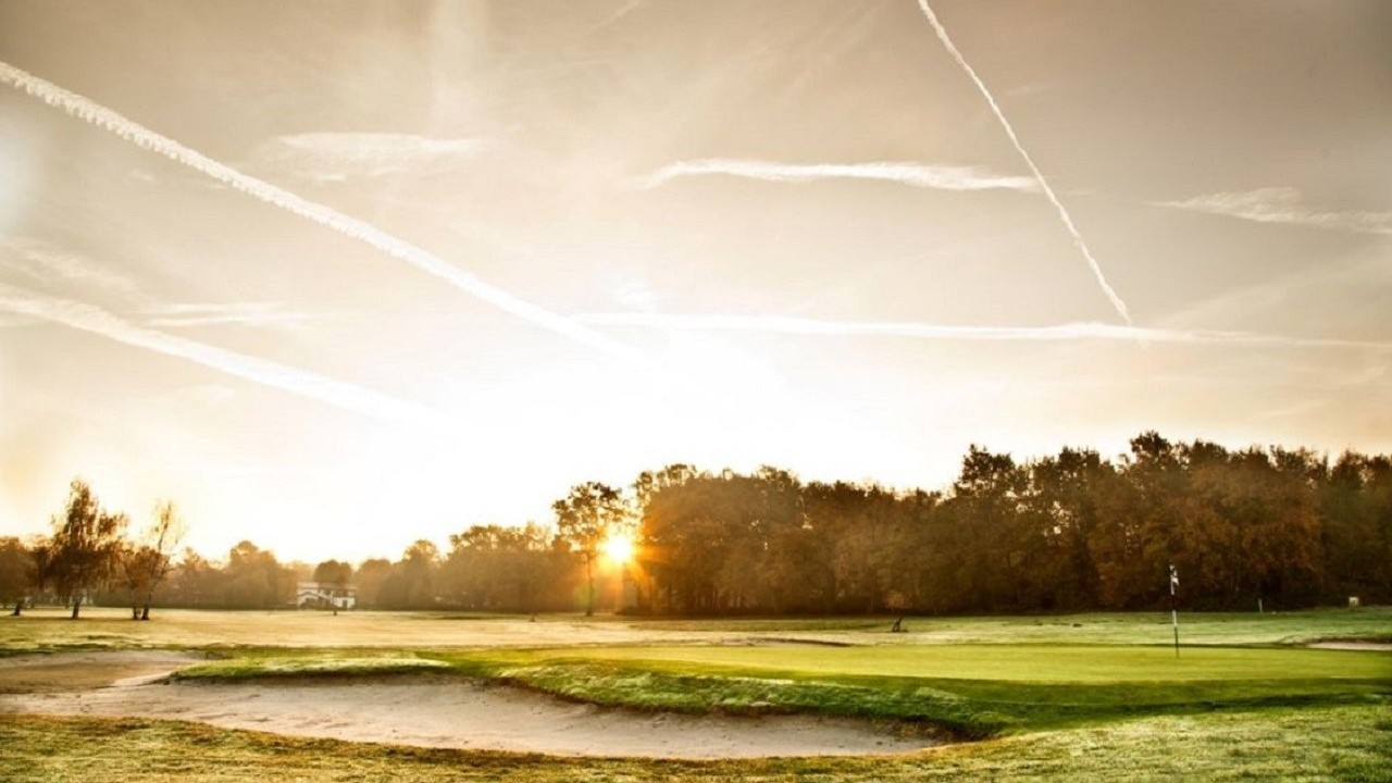 Green et bunker sous un soleil bas au golf de Bordeaux-Cameyrac.