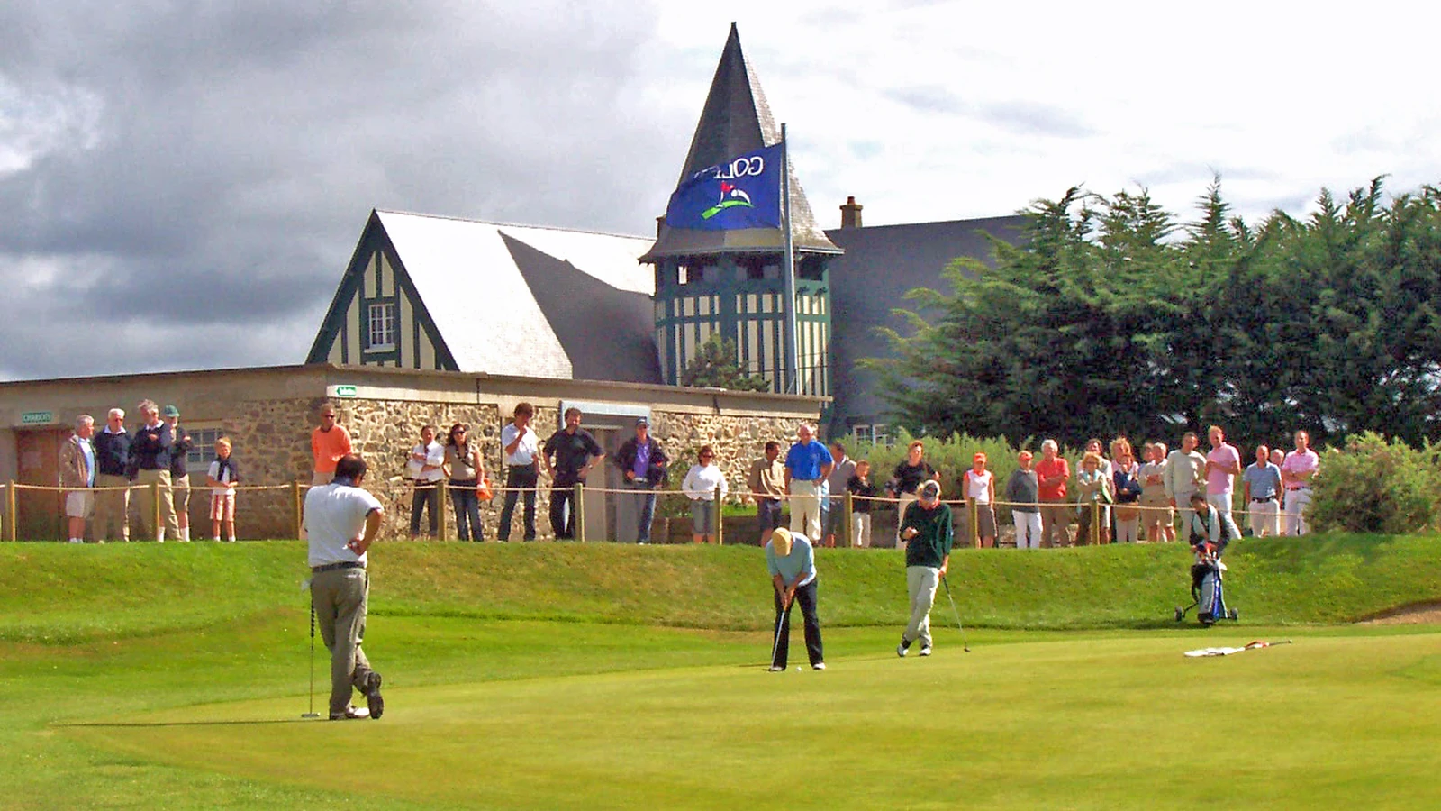 Golfeurs sur le green du Golf de Granville devant le club-house.