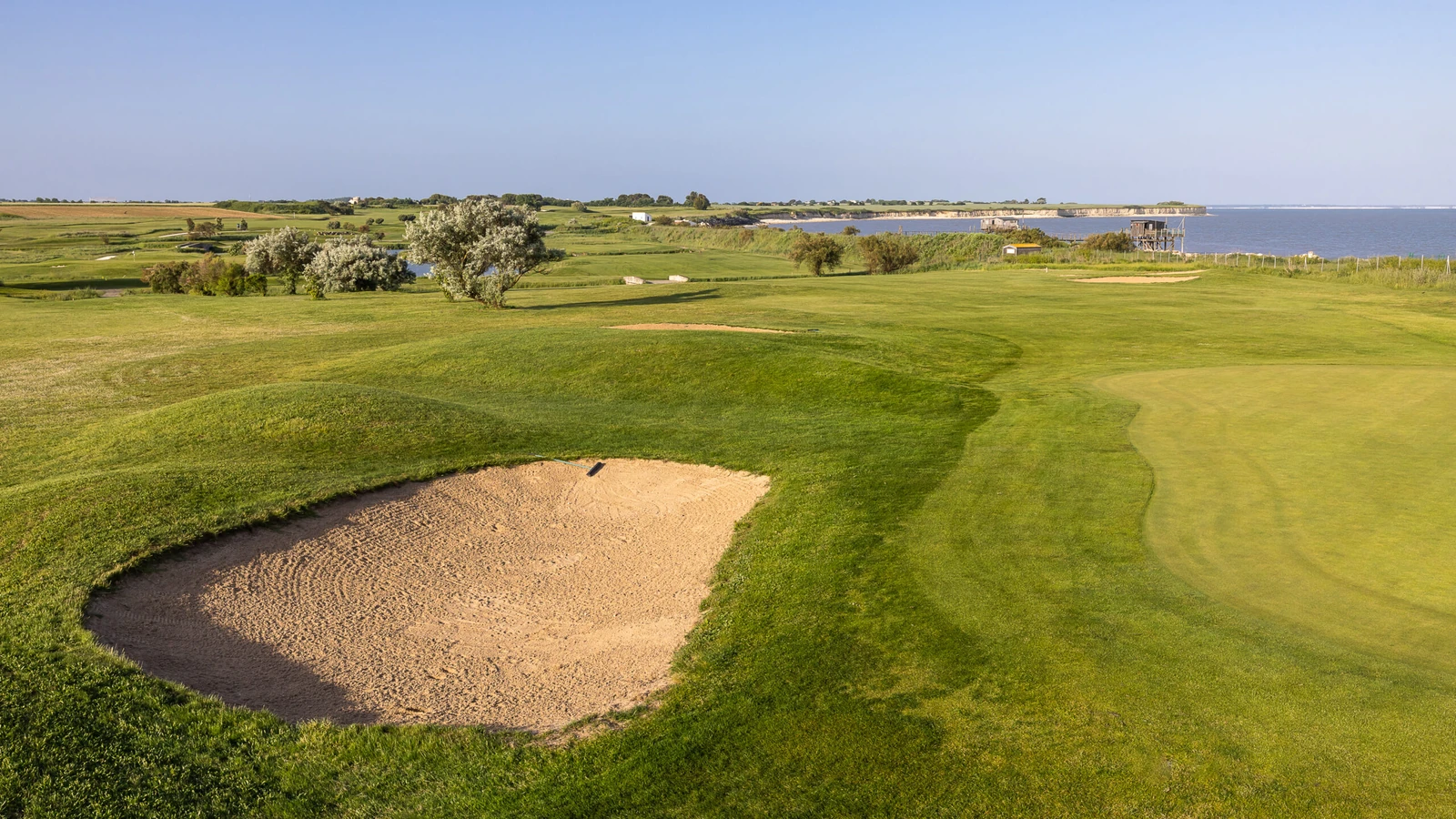 Bunker et green du Golf de La Prée – La Rochelle, avec le littoral à l’arrière-plan.