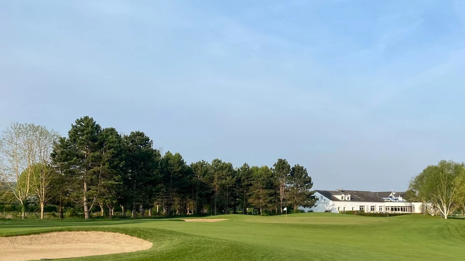 Vue du green et du fairway du Golf de Léry-Poses devant le club-house.
