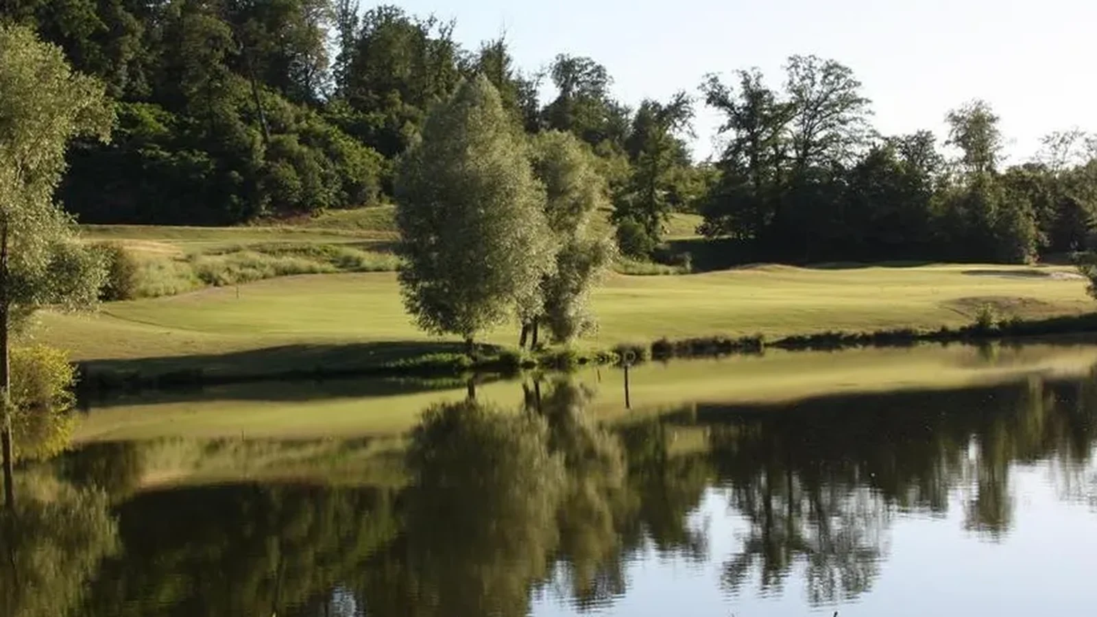 Green et plan d’eau dans le domaine arboré du Golf de Saint-Marc.
