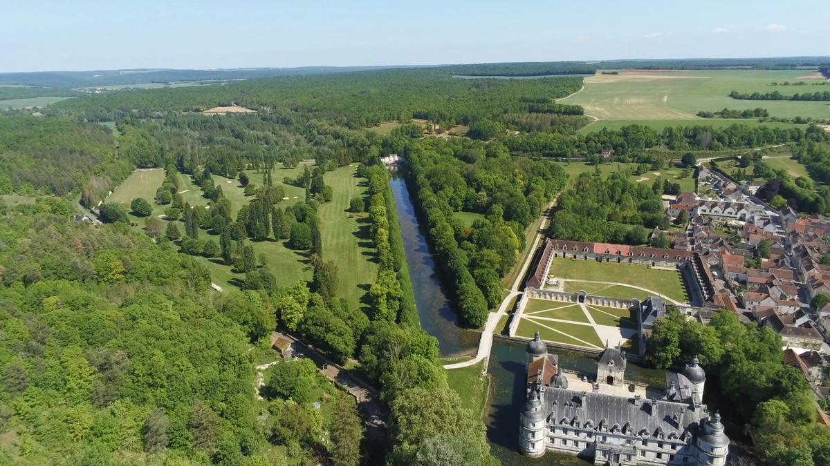 Vue aérienne du château, du canal et du terrain ; golf intégré au paysage. — Golf du Château de Tanlay