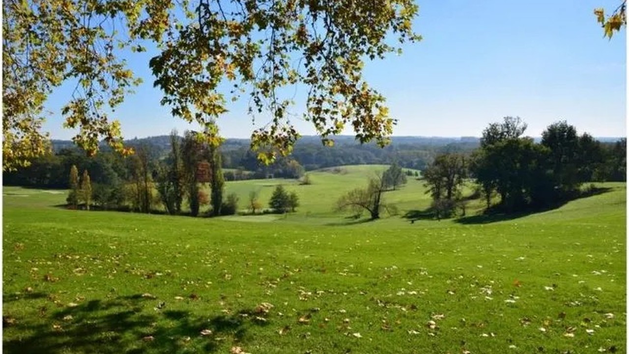 Vue du parcours vallonné de Teynac, entre pelouses et arbres.