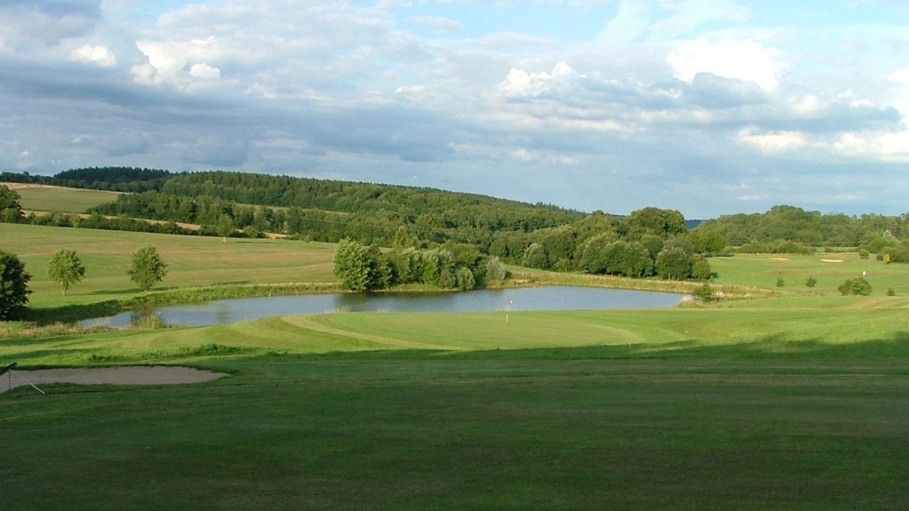 Green, bunker et pièce d’eau du Golf des Poursaudes dans un paysage vallonné et boisé