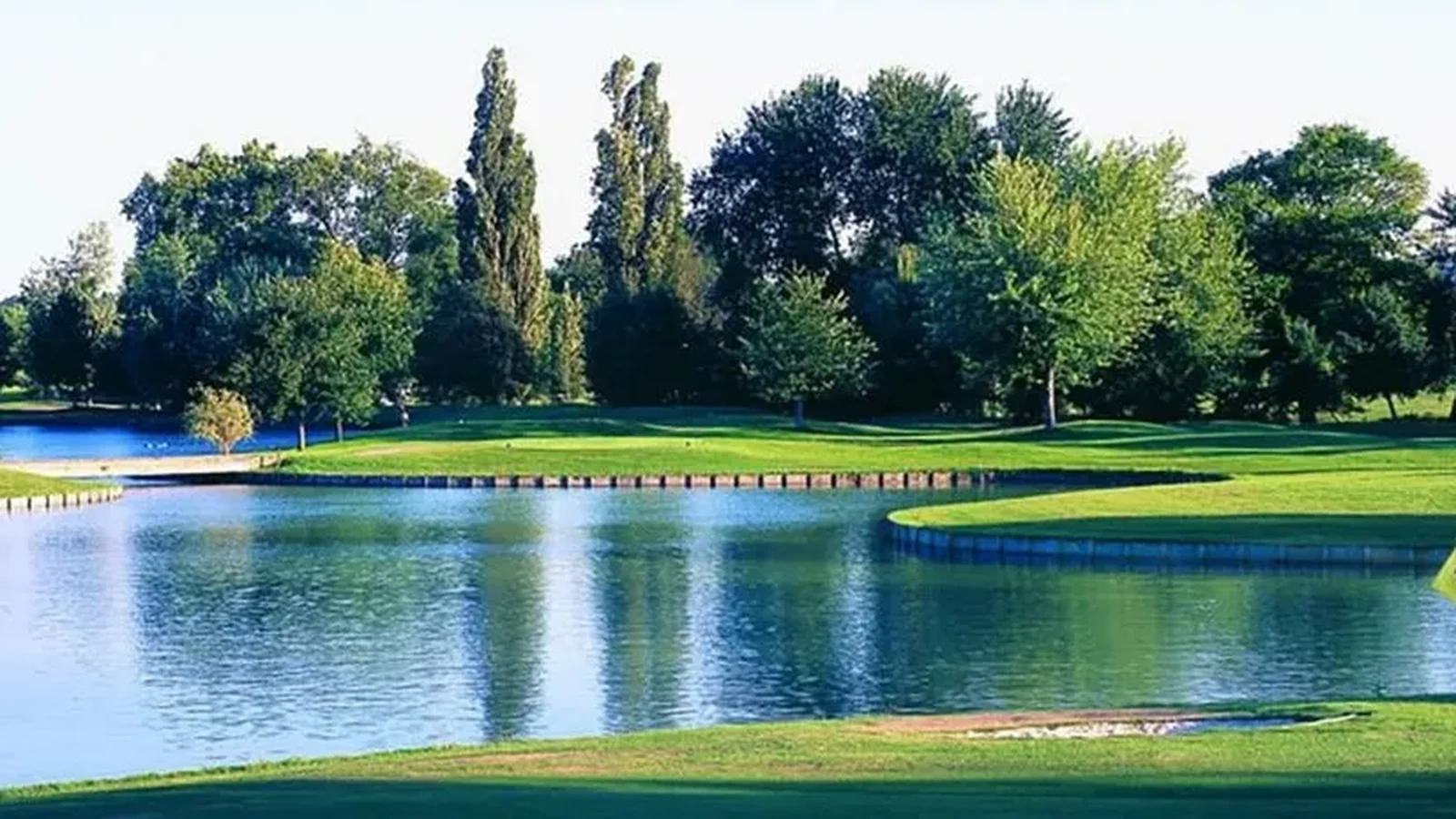 Green bordé par un vaste obstacle d’eau au Golf du Château de Cély.