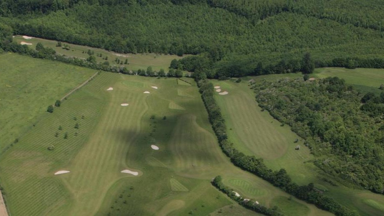 Vue aérienne des fairways et bunkers du Golf du Parc d’Olhain, à la lisière de la forêt.