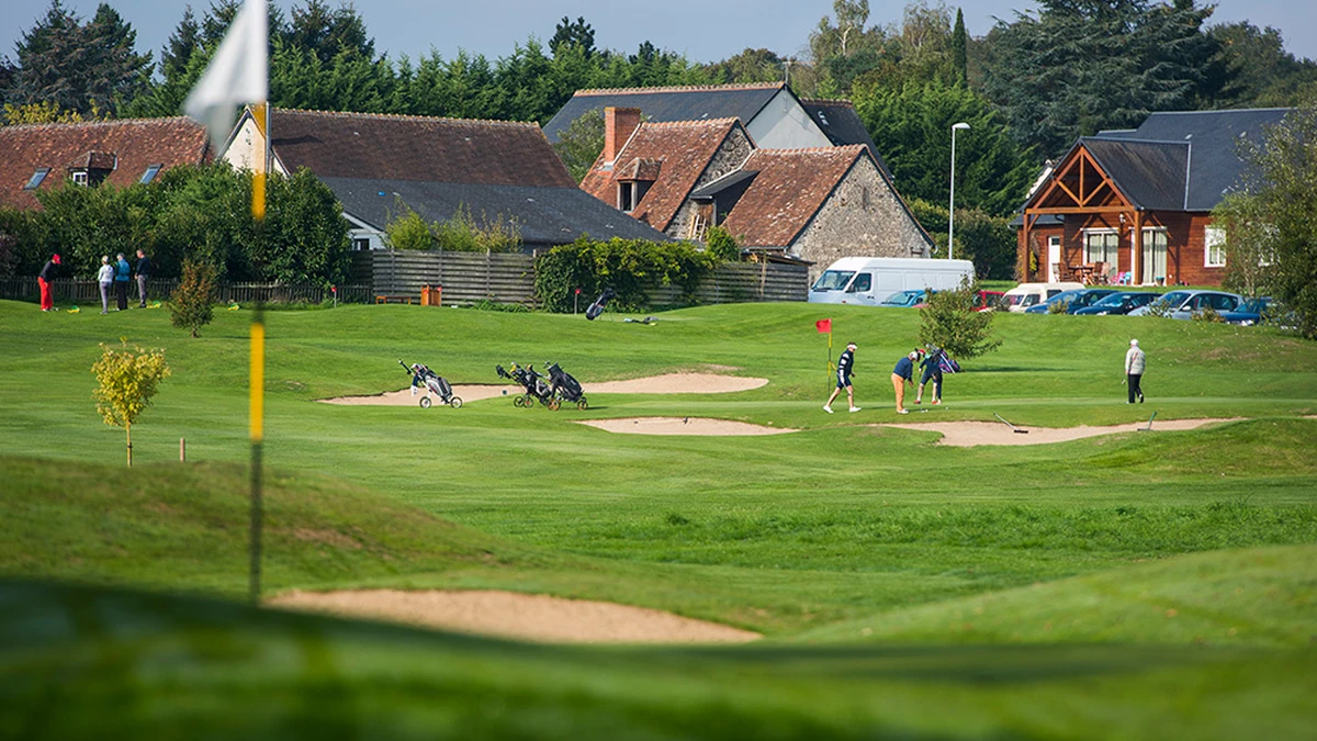 Green d’entraînement avec joueurs et bâtiments du club. — Golf de Loches-Verneuil