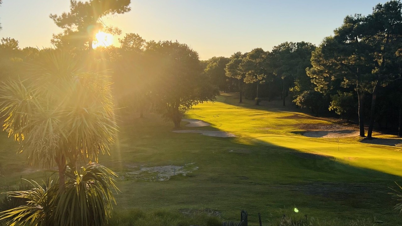 Fairway bordé de pins et bunker éclairés par le soleil au Golf de Lacanau Ardilouse.