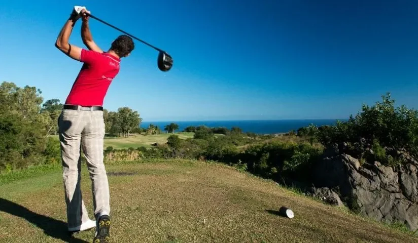 Joueur au départ face à l’océan — Golf du Bassin Bleu