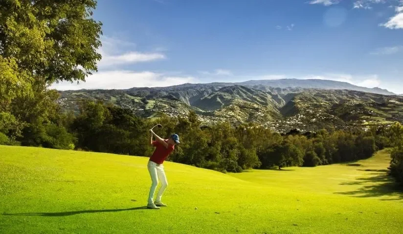 Joueur sur le parcours face aux montagnes — Golf de Bourbon