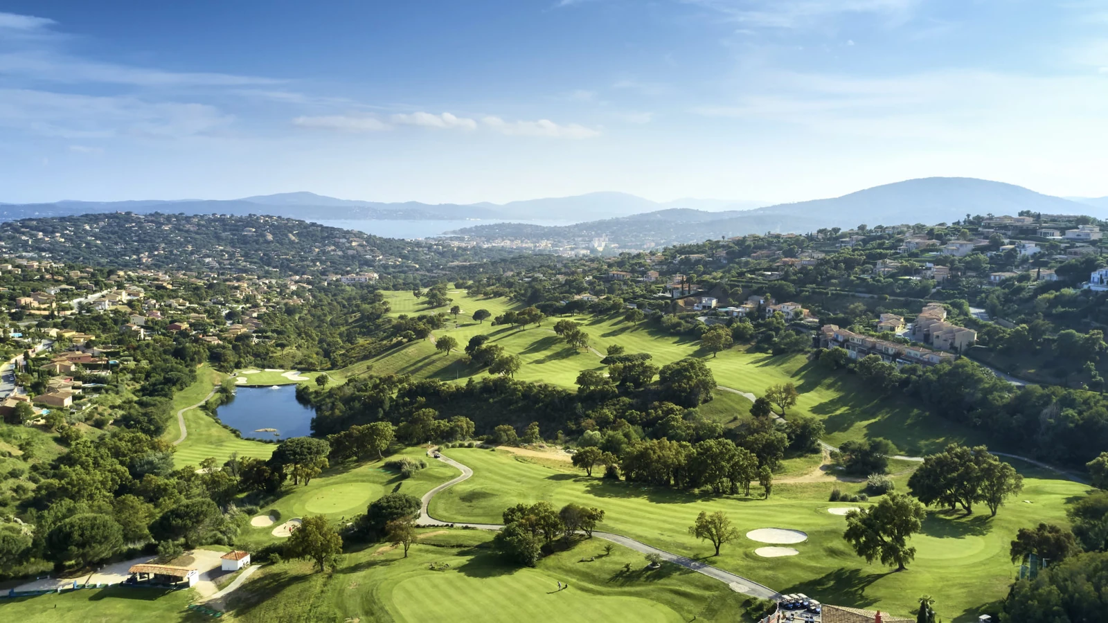 Vue aérienne du Golf Bluegreen Sainte-Maxime, entre fairways vallonnés, bunkers et plan d’eau.