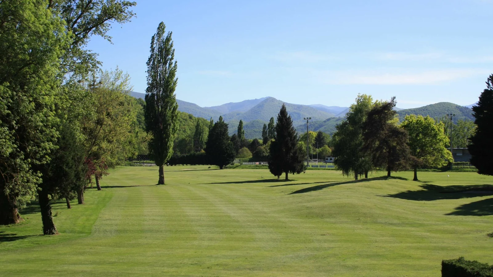 Fairway du trou 1 du Golf du Comminges avec les Pyrénées en arrière-plan.