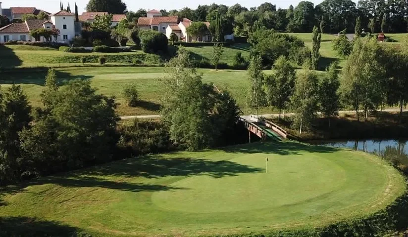 Green et passerelle devant les bâtiments — Golf international de la Prèze