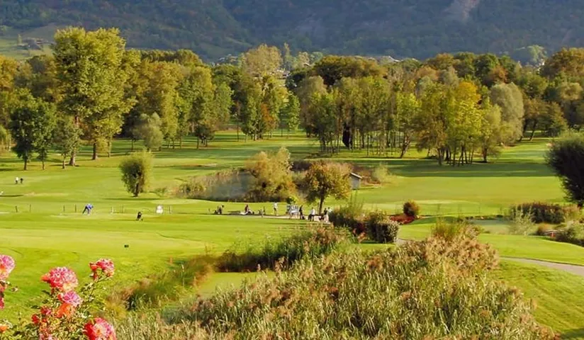 Parcours du Golf des Alpes bordé d’arbres et de massifs fleuris.