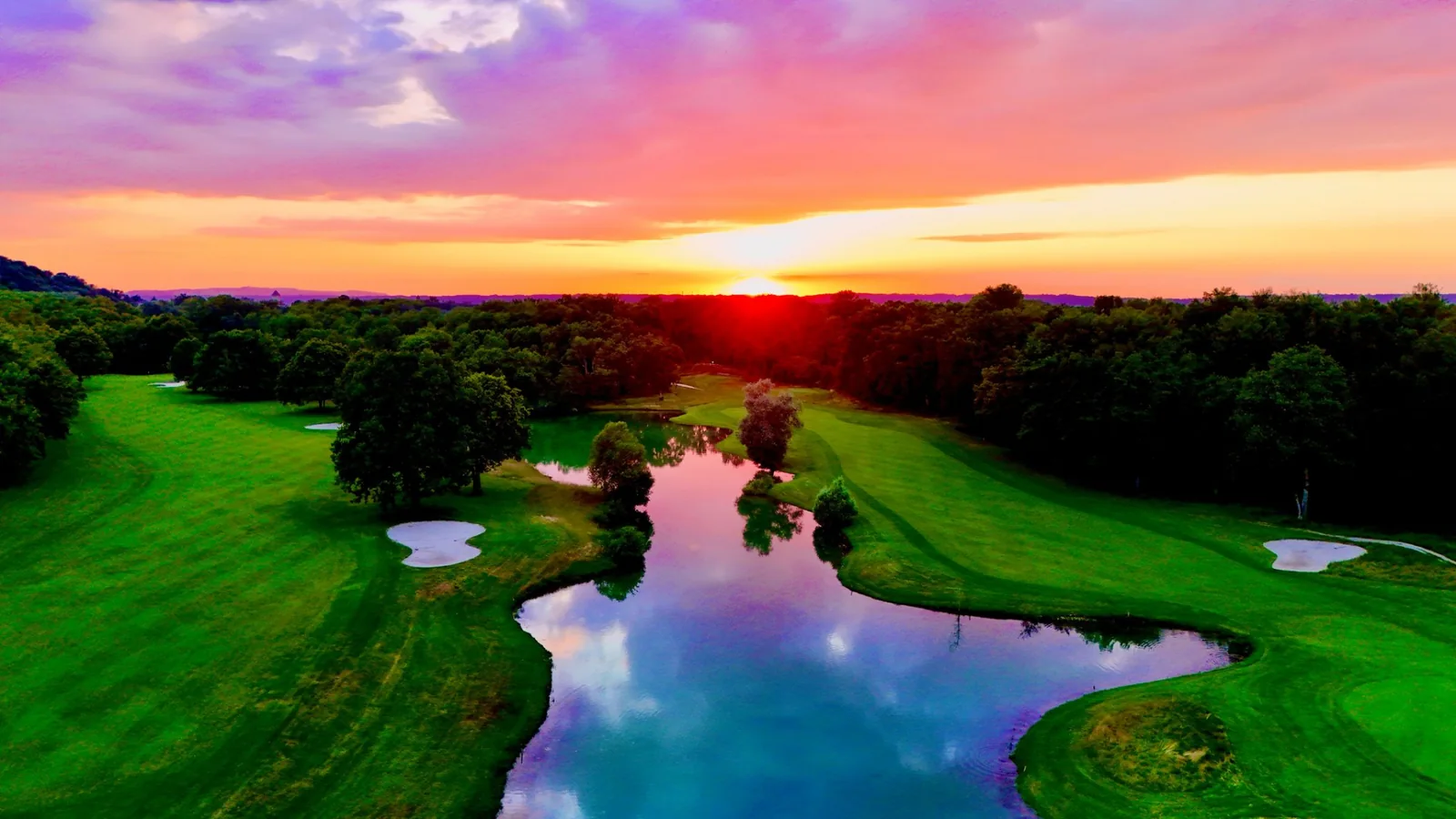 Plan d’eau et greens du Golf Club de Lyon au coucher du soleil