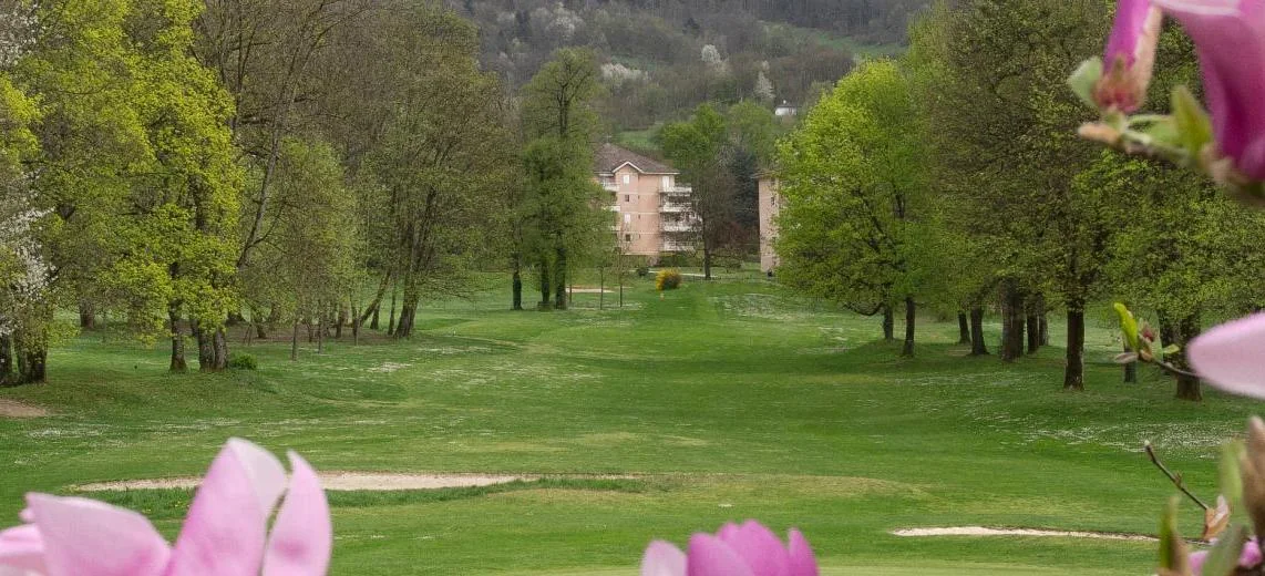 Vue du parcours d’Uriage entre arbres et fleurs au premier plan