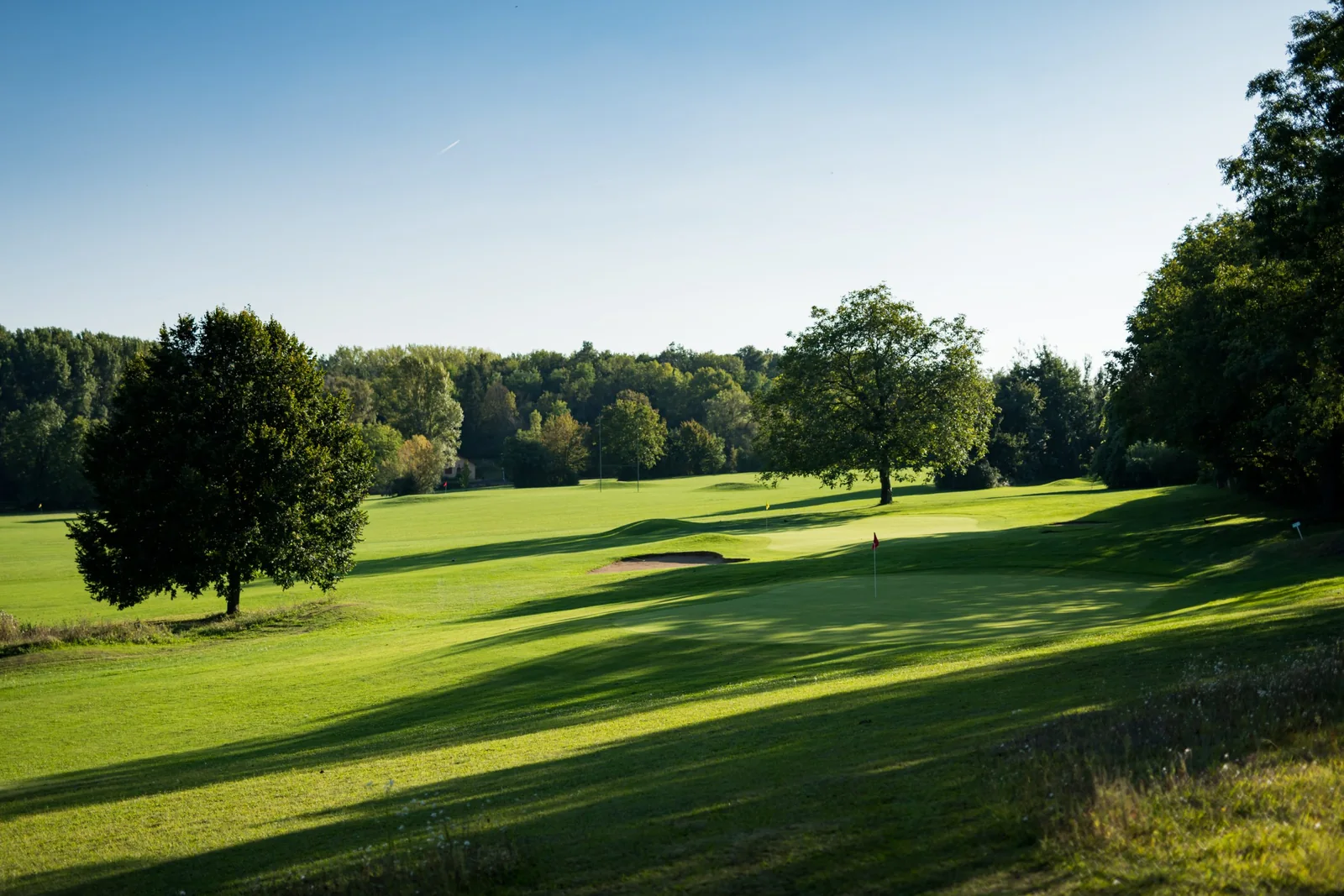 Fairway arboré des Trois Vallons dans la lumière du soir