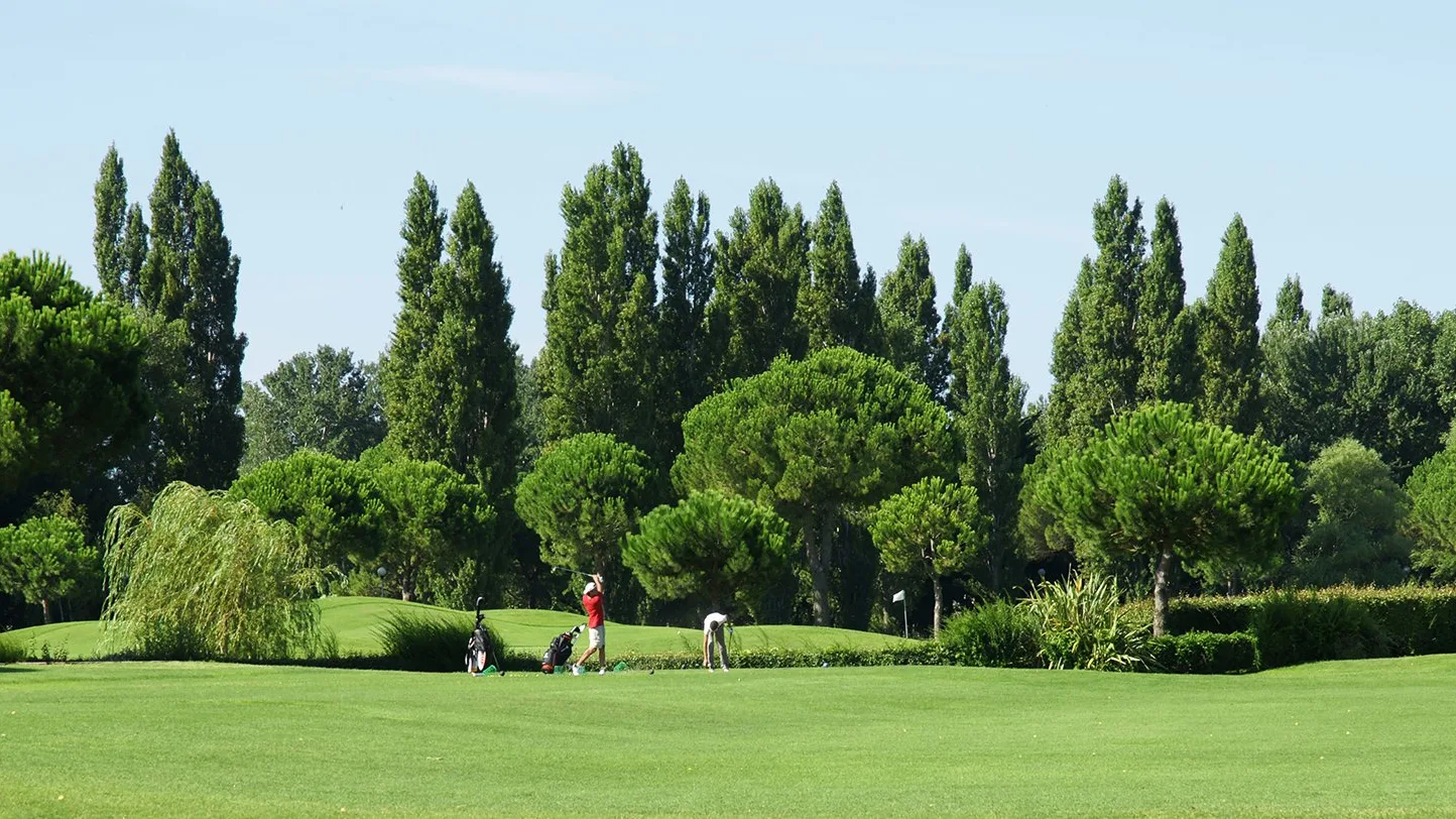 Fairway, pins et peupliers, avec quelques golfeurs au loin