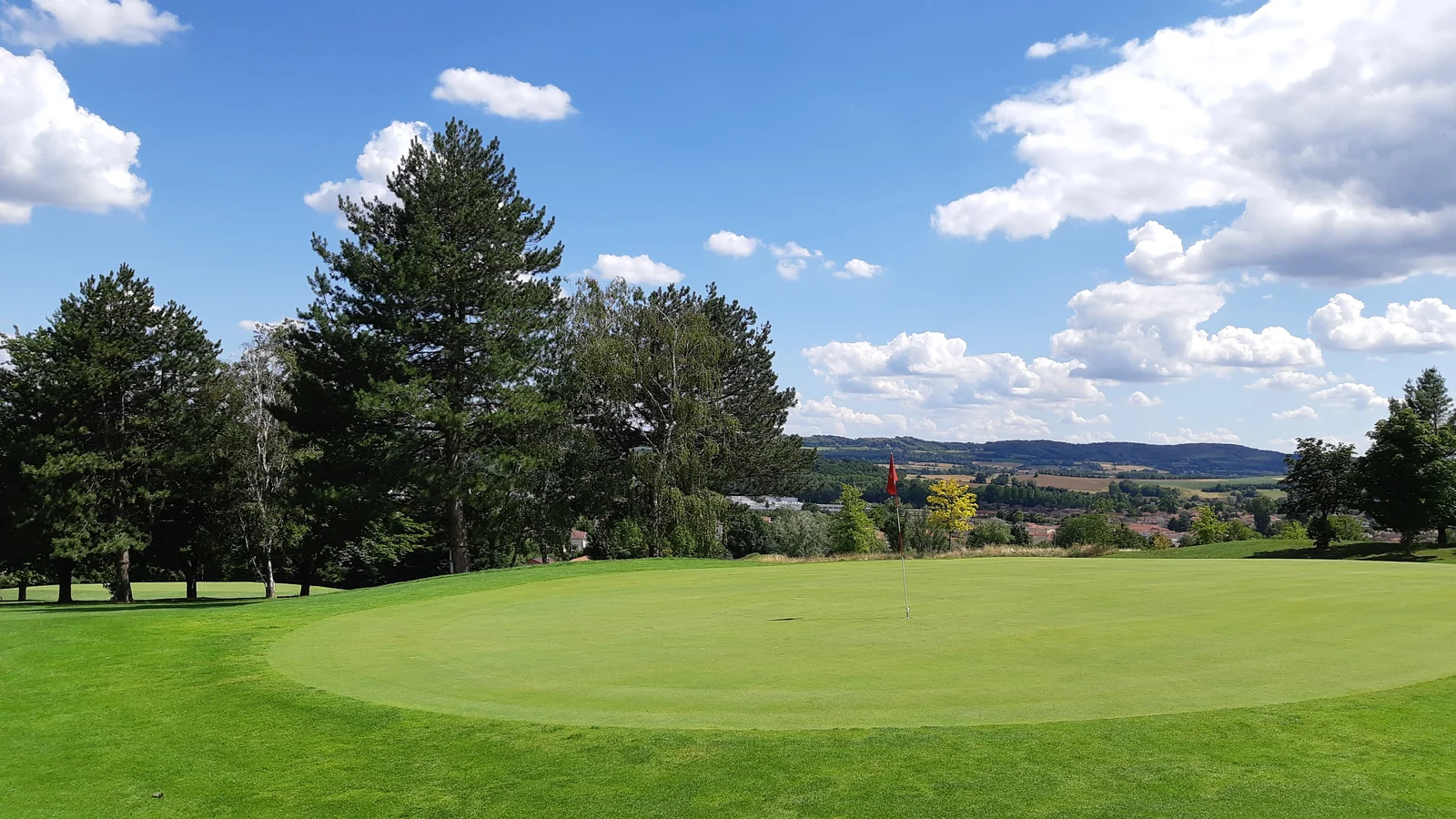 Green bordé d’arbres et panorama au Golf de Lyon Verger.