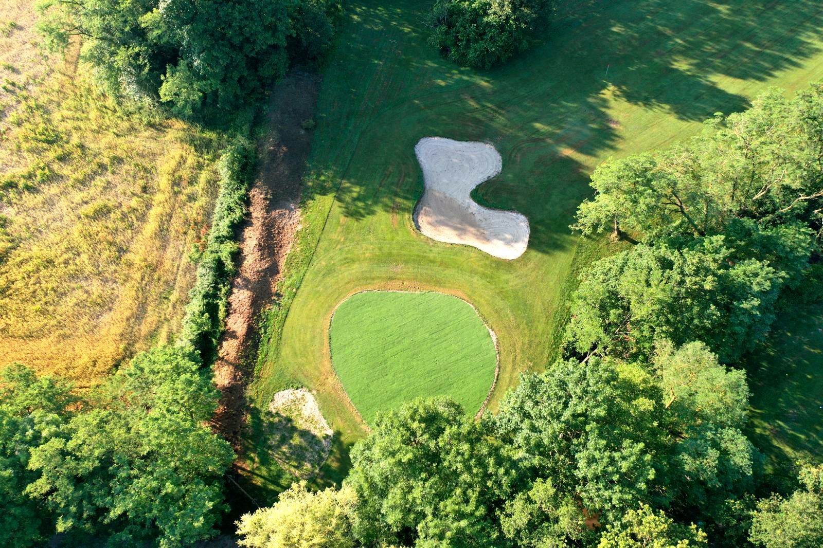 Vue verticale d’un green et d’un bunker au Golf des Étangs à Savigneux.