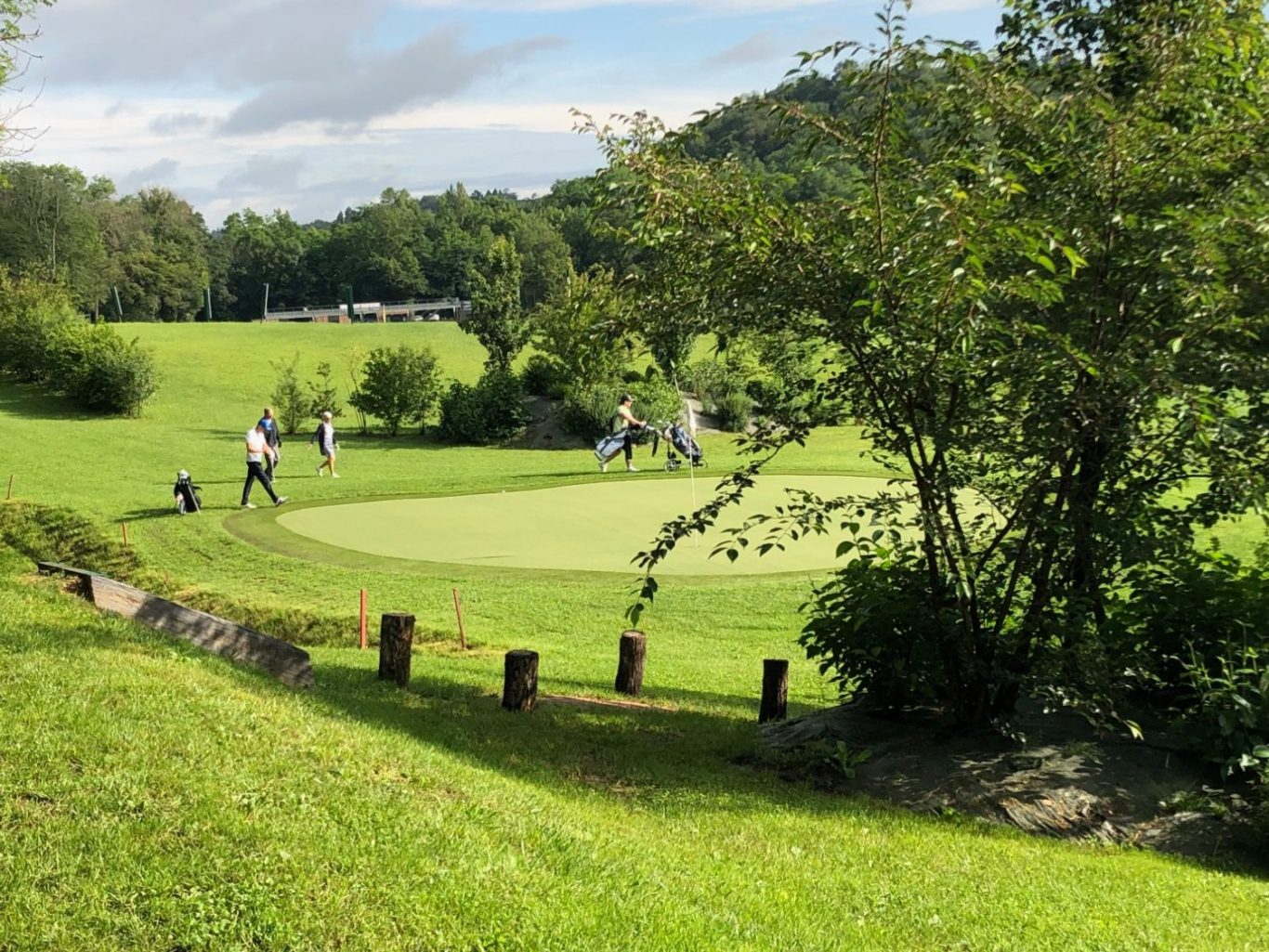 Vue d’ensemble du parcours du Golf Lyon Tassin avec des joueurs au loin.