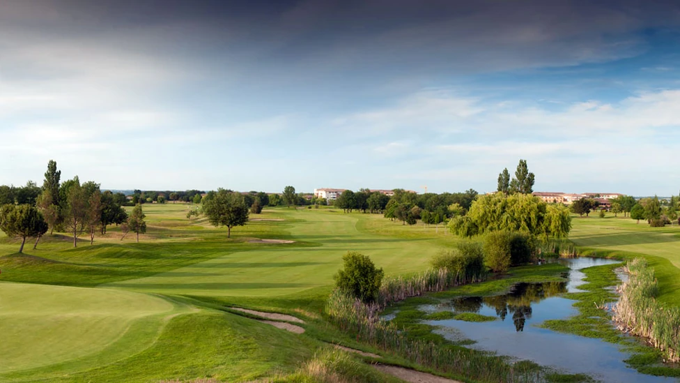 Green et fairway du Golf de Toulouse Seilh, au bord d’une pièce d’eau.